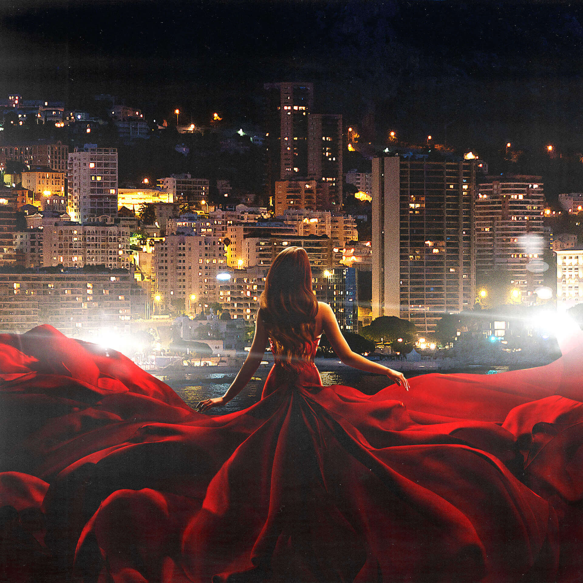 Woman in red dress looking at night city landscape